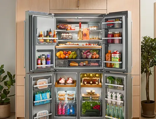 KitchenAid 4-door refrigerator fully stocked to show freestanding storage capacity and organization.